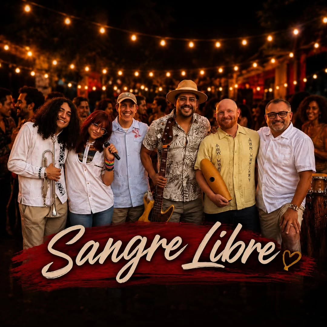 Sangre Libre band members smiling together on stage under warm string lights
